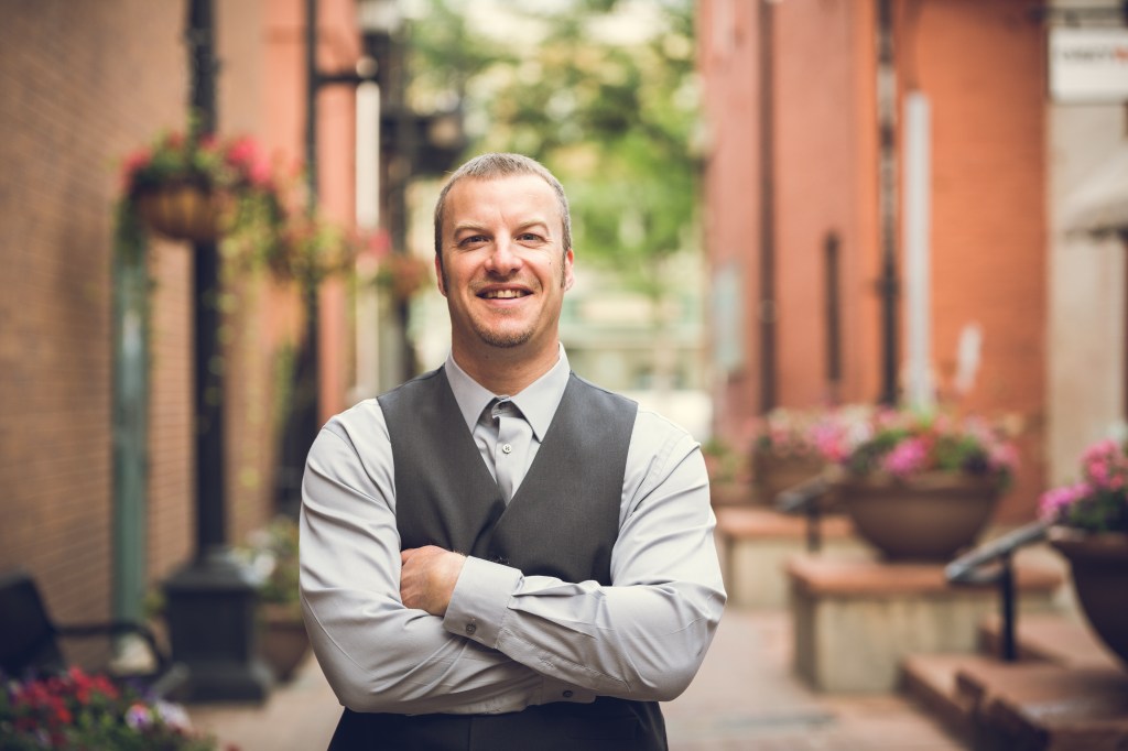 Jason Chadock smiling with arms crossed, confident leadership portrait